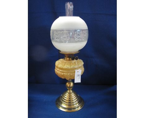 Early 20th century brass double burner oil lamp having relief moulded glass reservoir on a brass pedestal base, together with