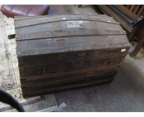 Vintage dome topped trunk with brass and wooden banding and cast metal loop handles. 