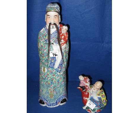 Large Chinese Canton porcelain enamel decorated figure of an immortal with long trailing natural moustache, holding a child. 