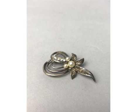 GEM AND FAUX PEARL BROOCH, set with three faux pearls and a row od white gems to a foliate spray, 46mm long