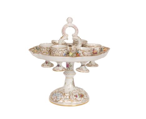 A DRESDEN PORCELAIN EGG CRUET, LATE 19th CENTURY, with double scroll handle above a tray fitted with six egg cups, on a flute