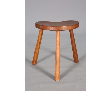 ROBERT THOMPSON OF KILBURNA MOUSEMAN OAK MILKING STOOL, with kidney shaped top and three splayed faceted legs, with carved mo