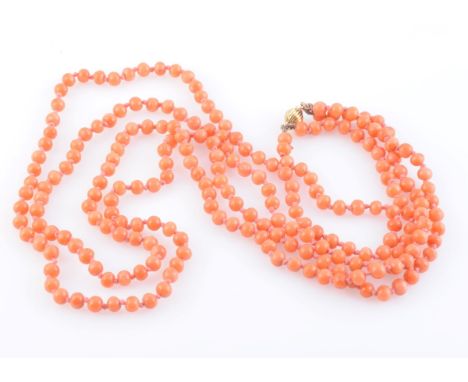 A CORAL BEAD NECKLACE, of uniform polished coral beads each strung knotted into two graduating rows, on an integral tongue ba