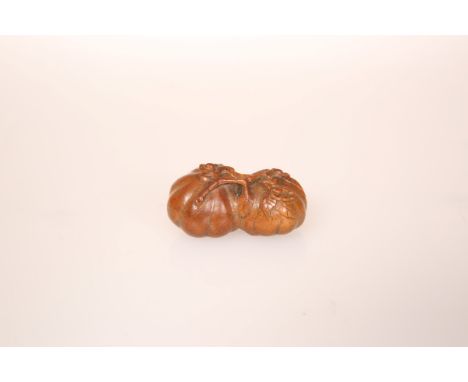 A JAPANESE WOOD NETSUKE, carved as persimmon fruit. 40mm