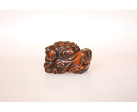 A JAPANESE WOOD NETSUKE OF A SHISHI HEAD, the scowling face with hinged jaw, opening to reveal the tongue within, the mane fa
