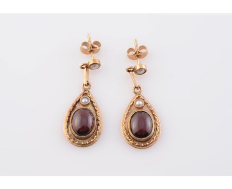 A PAIR OF GARNET AND SEED PEARL EARRINGS, the tapering oval drop with delicate rope work detailing set to the centre with an 