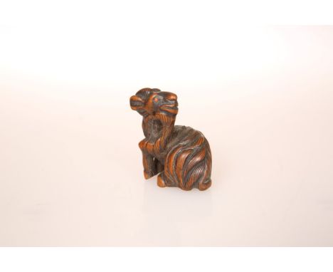 A JAPANESE WOOD NETSUKE OF A GOAT, carved with head turned back and with inlaid eyes, 19th Century. 42mm