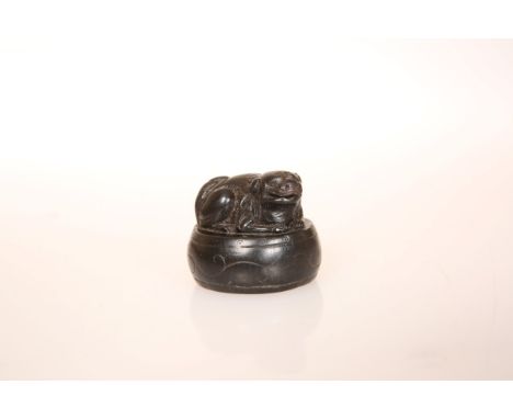 A JAPANESE EBONY NETSUKE, carved as a shishi, 19th Century. 31mm high