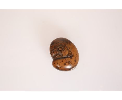 A JAPANESE WOOD NETSUKE OF DARUMA, 19th Century, carved with his body enveloped in a robe, signed to a reserve. 43mm