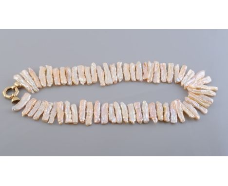 A KESHI PEARL NECKLACE, the sixty graduating keshi pearls each strung knotted onto a heavy octagonal shaped clasp. Clasp stam