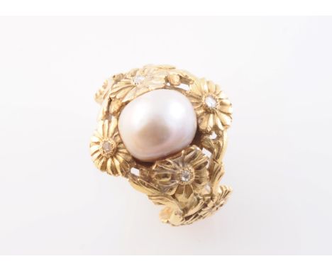 A NATURAL SALTWATER PEARL RING, the large single saltwater pearl set within an elaborately moulded floral mount on a tapering