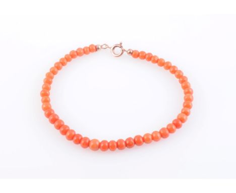 A CORAL BEAD BRACELET, the forty-seven uniform coral beads strung simply onto bolt ring clasp. Total length 17cm. Weight 4.8 