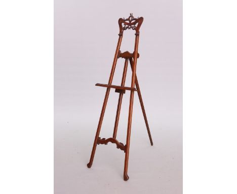 AN ART NOUVEAU CARVED MAHOGANY EASEL, the crest carved as whiplash and stylised foliage. 166cm
