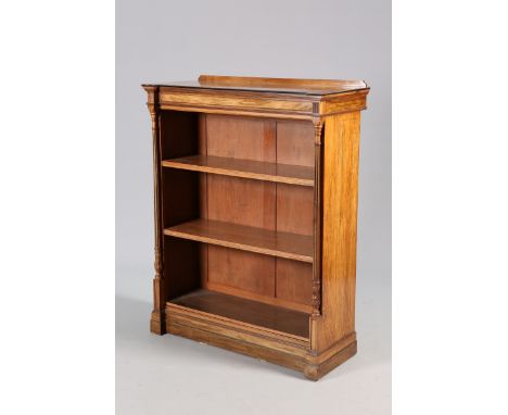 A VICTORIAN WALNUT OPEN BOOKCASE, with inverted break-front and fluted columns, raised on a plinth base. 131cm by 101.5cm by 