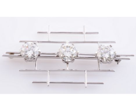 A DIAMOND BROOCH, the geometric stylised mount set to the centre with three individually claw set brilliant cut diamonds, on 