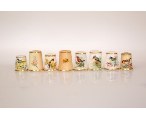 A COLLECTION OF EIGHT PORCELAIN THIMBLES, probably all Royal Worcester but only two marked, each painted with a bird and foli