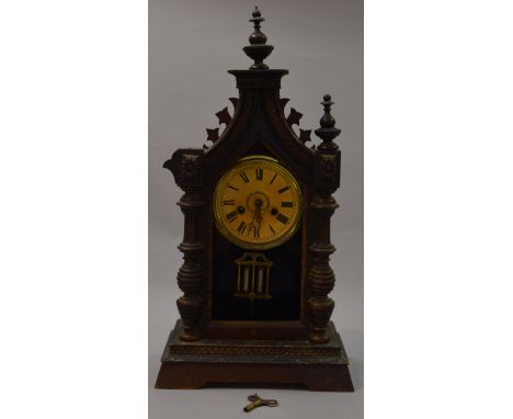 A wooden cased chiming mantle clock with mercury pendulum.