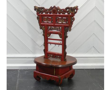 A Chinese red and gold lacquer foot binding stool, decorated and carved with two dragons at the top, scroll, bird and flower 