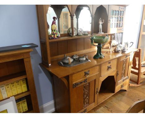 An Arts &amp; Crafts light oak Dresser, in the manner of Shapland &amp; Petter, Barnstaple, of asymmetric form, the mirrored 
