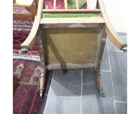 A Victorian pitch pine framed Armchair, with stick back and scroll arms, upholstered green armrests, back and pad seat, raise