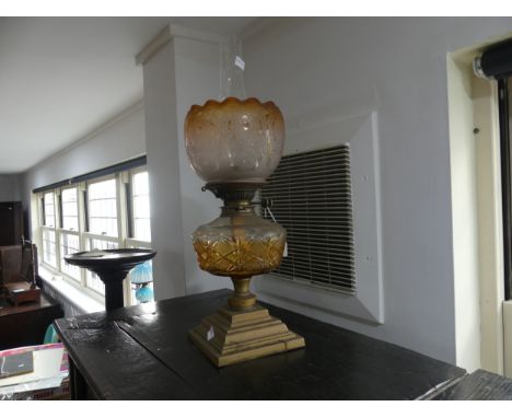 A Victorian brass squat Oil Lamp, having an amber glass font and floral etched shade, on stepped plinth base, nibbles to shad