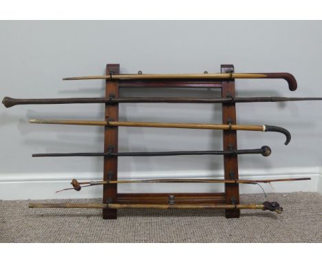 An Edwardian mahogany wall-mounted Stick Stand, with six pairs of hooks, W:51cm x H:61cm, together with six various walking s