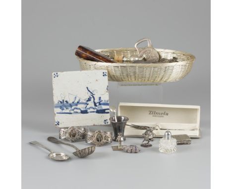 Consisting of a.o. a tile, bread basket, bottle stoppers, perfume bottle (silver), cake fork, napkin rings, various boxes, et
