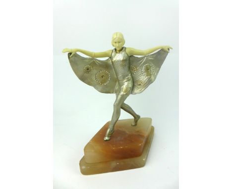 An Art Deco patinated spelter and ivorine figure group
Modelled in the form of a flapper girl holding her dress, raised on di