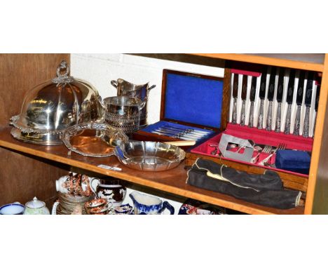 A shelf of silver plate including an old Sheffield plate meat dome, a canteen, a dish, other cutlery etc