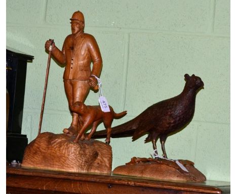 K Bateson, a carving of a pheasant on a naturalistic base, dated 1978 together with another carving of a huntsman and hound b