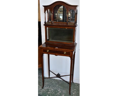 An Edwardian mahogany inlaid mirror back display cabinet, shaped top with three arched apron, turned columns above a bevel ed