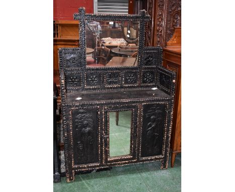 A black painted mirrorback side cabinet, mirror flanked by carved panels to top, central mirrored door flanked by carved pane