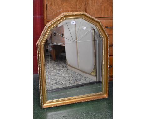 A late 20th century gilt wall mirror, canted top, bevelled plate 
