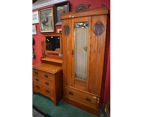 An Art Nouveau satinwood three piece bedroom suite comprising, single wardrobe, cretsing cornice, central mirrored door flank