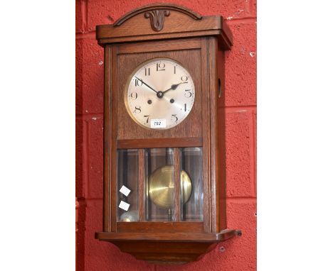 A 1940's oak wall clock, silvered dial, Arabic numerals.