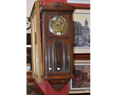 A 1940's oak wall clock, brass dial, Arabic numerals.