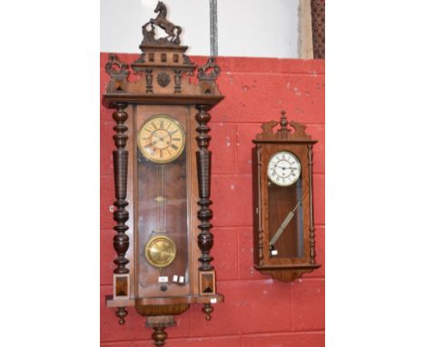 A late 19th century Vienna wall clock, Roman numerals, twin winding holes, pediment and finials, horse crests, key; a smaller