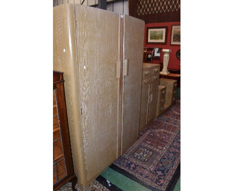 A limed oak effect bedroom suite comprising double wardrobe, tallboy an dresser.