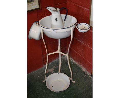 A metalwork wash stand with enamel bowl; enamel soap dish; jug; another enamel bowl; enamel chamber pot