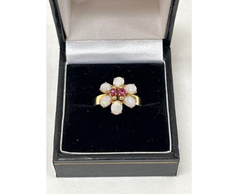 An 18ct opal and ruby ring with flower head setting. 3.5g gross. Size N.