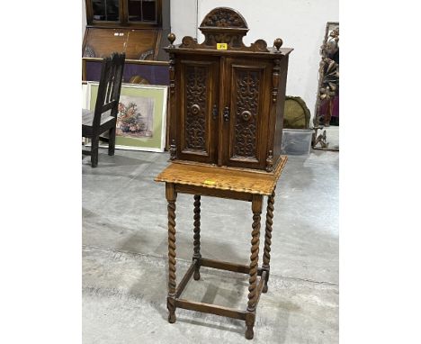 A Victorian walnut mural cupboard enclosed by a pair of blind fret carved doors, 24" high, together with a 1920s oak barleytw