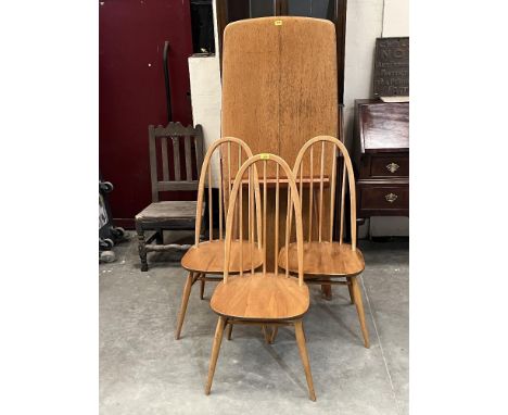 A set of three Ercol stickback chairs and a dining table.