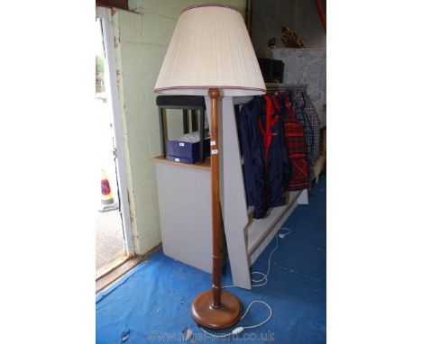 A turned wood standard lamp with shade.