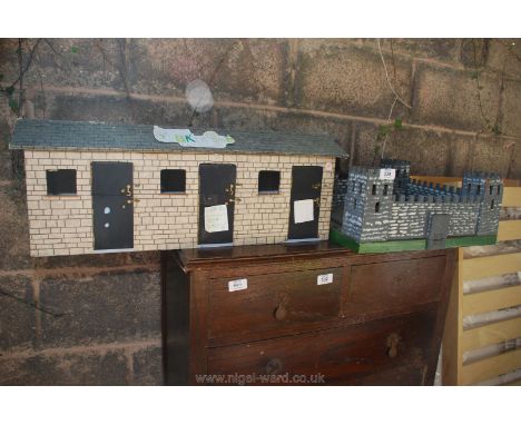 A wooden model castle and stables.