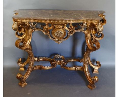 A French Gilded Console Table, the variegated serpentine marble top above a carved frieze raised upon triple scroll supports 