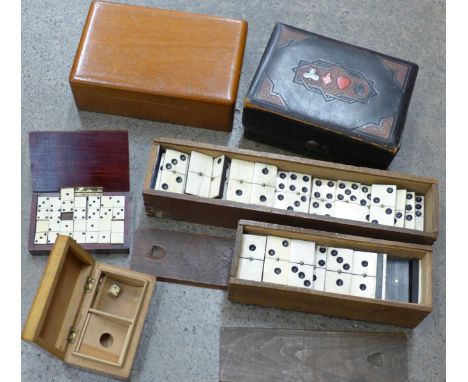 A set of miniature bone and ebony dominoes, two part sets of dominoes, a playing card box and two other wooden boxes