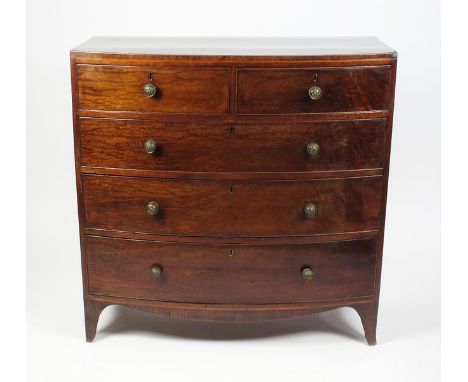 A Regency mahogany bow front chest of two short and three graduated cock beaded drawers with gilt brass lion mask knob handle