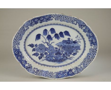 Three Chinese blue and white dishes18th CenturyThe first of lobed oval shape and decorated with a scene of rocks, trees, flow