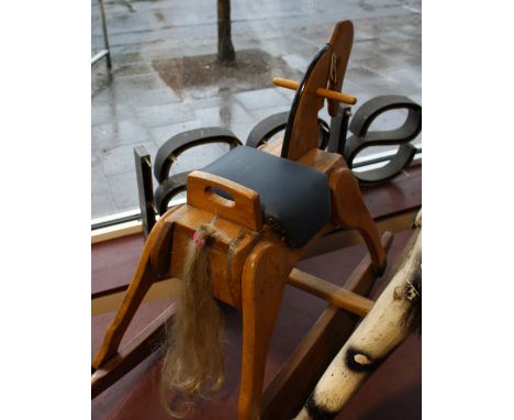 A small carved oak rocking horse with blue leatherette seat, L. 92cm.