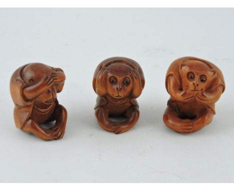 Three carved hardwood netsuke, in the form of the Wise Monkeys.